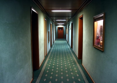 The empty corridor covered with green carpet
